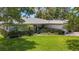 Charming single-story home with a lush green lawn, mature trees, and well-maintained landscaping at 1137 Indian Rocks S Rd, Largo, FL 33770