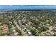 Aerial view captures a residential neighborhood with tree-lined streets, surrounded by lush greenery and blue skies at 1137 Indian Rocks S Rd, Largo, FL 33770