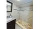 Bathroom with earth toned stone style tile, vanity and matching mirror at 6806 Monique Ave, Tampa, FL 33625