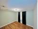 Bedroom with light walls, wood flooring and modern light fixture with window and curtains at 6806 Monique Ave, Tampa, FL 33625