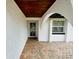 Arched entryway with brick flooring, a wooden ceiling, and a secure screen door at 6806 Monique Ave, Tampa, FL 33625