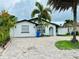 Charming home with a brick driveway, a white stucco exterior, and lush tropical landscaping in the front yard at 6806 Monique Ave, Tampa, FL 33625