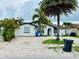 Inviting white home featuring a brick driveway, an arched entryway, and lush tropical landscaping in the front yard at 6806 Monique Ave, Tampa, FL 33625