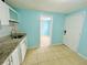 Modern kitchenette with white cabinets, stainless steel faucet, granite countertops, and tiled floor at 6806 Monique Ave, Tampa, FL 33625