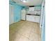 Small kitchenette features white cabinets, tile backsplash and appliances in a tiled room at 6806 Monique Ave, Tampa, FL 33625