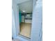 Small kitchenette features white cabinets, tile backsplash and appliances in a tiled room viewed from door at 6806 Monique Ave, Tampa, FL 33625