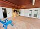 Covered brick patio featuring a charming tiki bar, blue lawn chairs and access to the pool at 6806 Monique Ave, Tampa, FL 33625