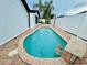 Kidney shaped in-ground pool with brick surround and stone topped bar in fenced backyard at 6806 Monique Ave, Tampa, FL 33625
