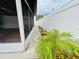 Cozy side yard featuring a white fence, potted plants, and walkway at 6806 Monique Ave, Tampa, FL 33625