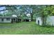 Lush backyard with mature trees, a shed, and a view of the home at 242 Zoller St, Brooksville, FL 34601