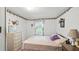 A serene bedroom featuring soft floral wallpaper and a cozy bed illuminated by natural light from the window at 242 Zoller St, Brooksville, FL 34601
