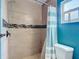 Bathroom featuring tiled walls, a tub with shower, and stylish fixtures at 7318 Tranquil Dr, Spring Hill, FL 34606