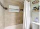 Bathroom featuring tiled walls, a tub with shower, and decorative mosaic tile at 7318 Tranquil Dr, Spring Hill, FL 34606