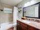 Bathroom with tile flooring, granite counters, framed mirror and tub with shower at 7318 Tranquil Dr, Spring Hill, FL 34606