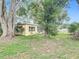 The house has a lovely backyard screened-in porch and is shaded by beautiful trees at 7318 Tranquil Dr, Spring Hill, FL 34606