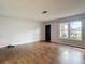 Well-lit living room with wood-look tile and view through a large window at 7318 Tranquil Dr, Spring Hill, FL 34606