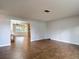 Spacious living room with wood-look tile floors flowing into the adjacent dining area at 7318 Tranquil Dr, Spring Hill, FL 34606
