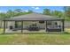 Large covered back patio featuring an outdoor dining table, comfortable seating, and a mounted television at 14025 Canyon Swallow Rd, Weeki Wachee, FL 34614