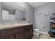 Bathroom features a double sink vanity with dark cabinets, a large mirror, and neutral paint at 14025 Canyon Swallow Rd, Weeki Wachee, FL 34614