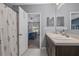 Bright bathroom features a double sink vanity, neutral tile floors, and a decorative shower curtain at 14025 Canyon Swallow Rd, Weeki Wachee, FL 34614