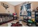 Decorated Bedroom features western-themed decor, dark wood crib, rocking chair, and ample light at 14025 Canyon Swallow Rd, Weeki Wachee, FL 34614