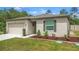 Attractive single-story home showcasing a well-maintained lawn, flower beds, and a two-car garage at 14025 Canyon Swallow Rd, Weeki Wachee, FL 34614