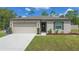 Charming single-story home featuring a manicured lawn, neutral stucco exterior, and a two-car garage at 14025 Canyon Swallow Rd, Weeki Wachee, FL 34614