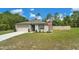 Beautiful single-story home featuring a spacious lawn, an American flag, and an attached two-car garage at 14025 Canyon Swallow Rd, Weeki Wachee, FL 34614