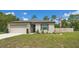 Inviting single-story home with a manicured lawn, tidy landscaping, and an attached two-car garage at 14025 Canyon Swallow Rd, Weeki Wachee, FL 34614