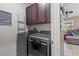 Laundry room featuring stainless steel washer and dryer, dark cabinets, and access to Gathering room at 14025 Canyon Swallow Rd, Weeki Wachee, FL 34614