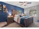 Comfortable main bedroom with blue accent wall and a ceiling fan at 14025 Canyon Swallow Rd, Weeki Wachee, FL 34614