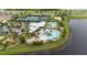 An aerial view displays the community clubhouse, pools, tennis, and basketball courts at 5528 Summer Sunset Dr, Apollo Beach, FL 33572