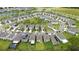 An aerial view captures a new neighborhood's layout with tree lined streets and meticulously manicured lawns at 5528 Summer Sunset Dr, Apollo Beach, FL 33572