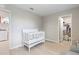 Bright Bedroom with white crib, access to closet, and nearby laundry room at 5528 Summer Sunset Dr, Apollo Beach, FL 33572