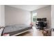 Bright bedroom featuring light hardwood floors, a window, and a minimalist design at 5528 Summer Sunset Dr, Apollo Beach, FL 33572