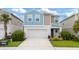 Charming two-story home with a two-car garage, neatly landscaped yard and blue and tan accent colors at 5528 Summer Sunset Dr, Apollo Beach, FL 33572