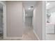 Bright hallway with light wood floors leading to a bathroom and laundry room at 5528 Summer Sunset Dr, Apollo Beach, FL 33572