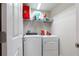 Well-lit laundry room with washer, dryer, and wire shelving for storage at 5528 Summer Sunset Dr, Apollo Beach, FL 33572