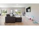A modern living room with wood floors, a sectional sofa, and plenty of natural light at 5528 Summer Sunset Dr, Apollo Beach, FL 33572