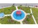 Aerial view of a modern playground with colorful equipment, seating, and palm trees at 5528 Summer Sunset Dr, Apollo Beach, FL 33572