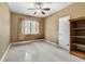 Tan empty bedroom with a window, fan, and a bookshelf at 39 Sunset Dr, Brooksville, FL 34601