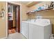 Convenient laundry room with washer, dryer, and shelving for storage at 39 Sunset Dr, Brooksville, FL 34601