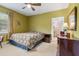 Green main bedroom with large bed, dark wood dresser, and adjoining bathroom at 39 Sunset Dr, Brooksville, FL 34601