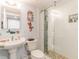 Bathroom with pedestal sink, toilet, and walk-in shower at 15316 Gulf Blvd # 301, Madeira Beach, FL 33708