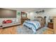 Cozy bedroom with wooden floors, a bed with a blue striped comforter, and a small couch at 6628 1St N St, St Petersburg, FL 33702