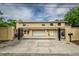 Gated driveway leading to a tan two-story home with attached garages at 6628 1St N St, St Petersburg, FL 33702