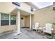 Inviting front entrance with white columns, a covered porch, and two white Adirondack chairs at 6628 1St N St, St Petersburg, FL 33702
