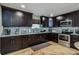 Modern kitchen with dark wood cabinets, stainless steel appliances, and granite countertops at 6628 1St N St, St Petersburg, FL 33702