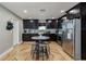 Kitchen with dark cabinets, stainless steel appliances, a round table with bar stools, and hardwood floors at 6628 1St N St, St Petersburg, FL 33702