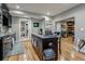 Compact kitchen with island, stainless steel appliances, and view of adjacent room at 6628 1St N St, St Petersburg, FL 33702